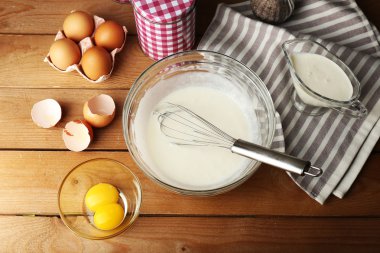 Hazırlık ahşap arka plan üzerinde cam kasede yumurta ile krem