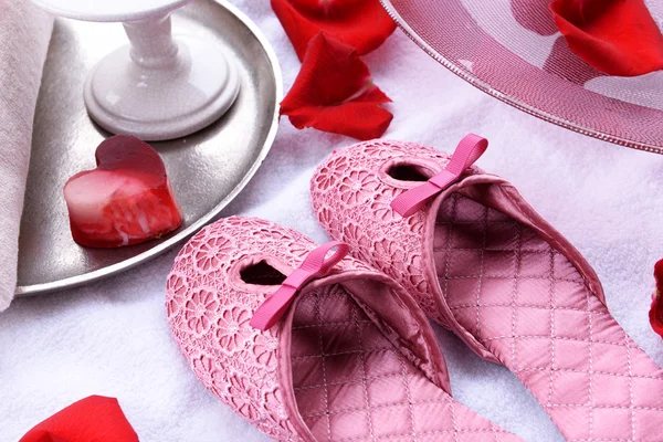 Bol spa avec eau, pétales de rose, serviette et pantoufles sur fond clair. Concept de pédicure ou de traitement spa naturel — Photo