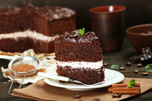 Delicioso bolo de chocolate na mesa no fundo marrom — Fotografia de Stock