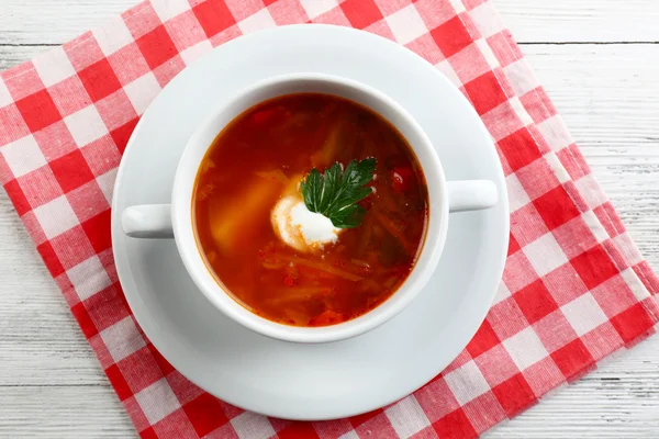 La sopa ucraniana de remolacha - borscht, sobre la servilleta, sobre el fondo de madera —  Fotos de Stock