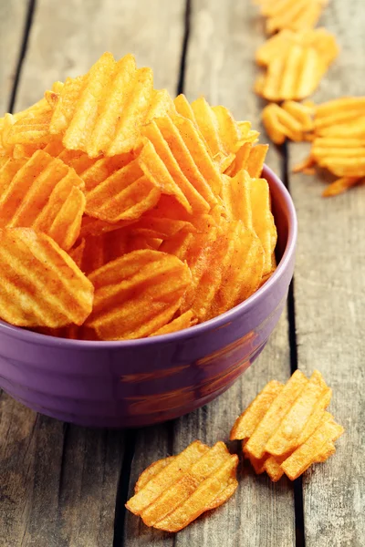 Deliciosas papas fritas en un tazón sobre una mesa de madera —  Fotos de Stock