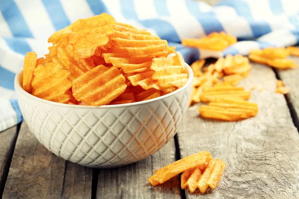 Deliciosas papas fritas en un tazón sobre una mesa de madera — Foto de Stock