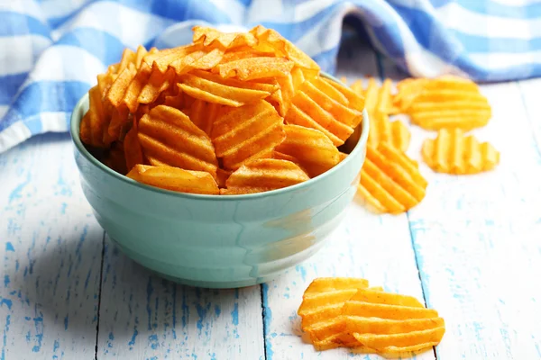 Deliciosas papas fritas en un tazón sobre una mesa de madera — Foto de Stock