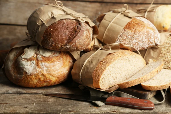 Pane fresco diverso, su vecchio tavolo di legno — Foto Stock