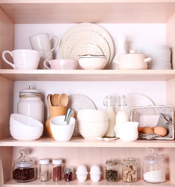 Keukengerei en servies op planken — Stockfoto