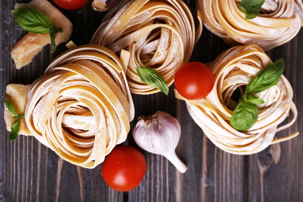 Raw homemade pasta with cheese and vegetables on wooden background — Stock Photo, Image