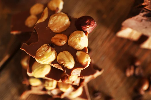 堆栈的木桌前，特写的果仁巧克力 — 图库照片