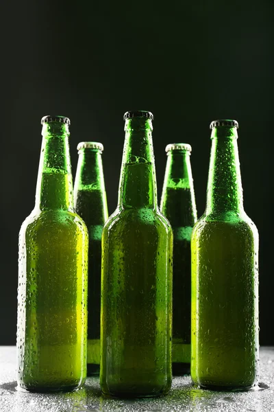 Szklane butelki piwa na ciemnym tle — Zdjęcie stockowe