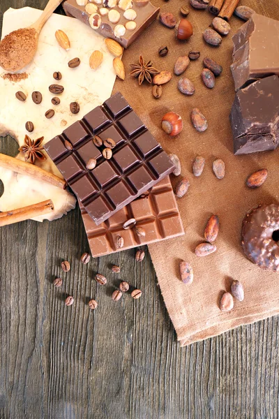 Delicious chocolates with nuts spices on table, closeup — Stock Photo, Image