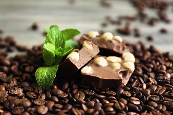 Chocolate with mint and coffee beans on wooden table, closeup — Stock Photo, Image