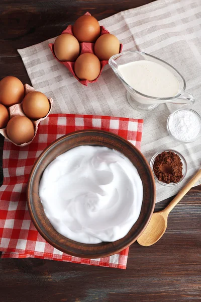 Blancs d'œufs fouettés et autres ingrédients pour crème sur table en bois, vue de dessus — Photo