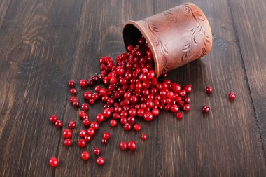 İle kil Kupası ahşap arka plan üzerinde kırmızı kızılcık