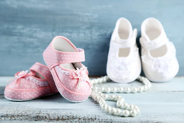 Zapatos para niños de color rosa y blanco sobre fondo de madera — Foto de Stock