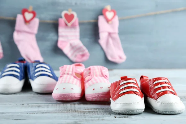 Cute toddler shoes and socks on wooden background — Stock Photo, Image