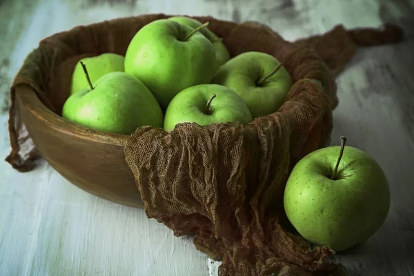 Pommes vertes dans un bol avec du tissu sur une table en bois, gros plan — Photo