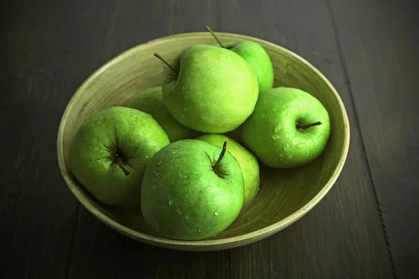 Pommes vertes dans un bol sur une table en bois, gros plan — Photo