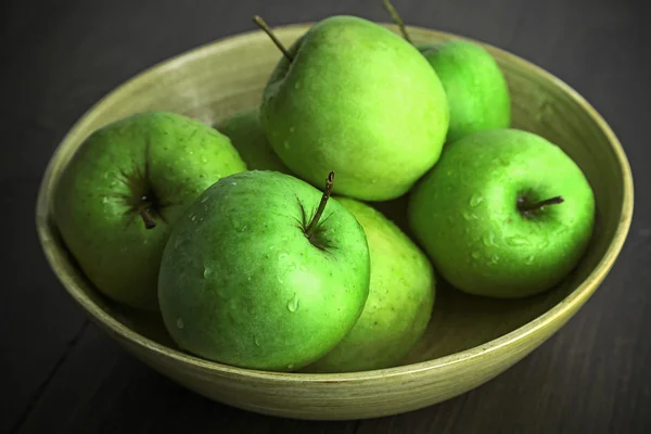 Pommes vertes dans un bol sur une table en bois, gros plan — Photo