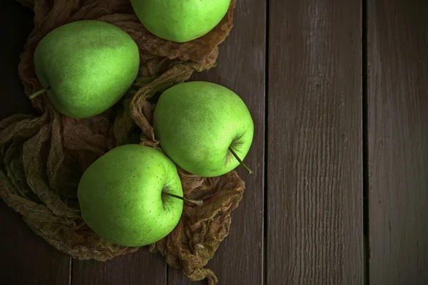 Grüne Äpfel auf Holztisch mit Stoff, Draufsicht — Stockfoto