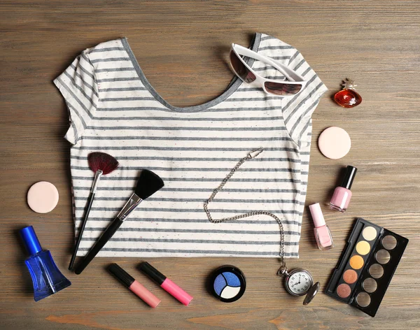 Çizgili tişört ve ahşap arka plan üzerinde çeşitli kozmetik — Stok fotoğraf