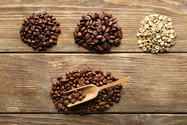 Grãos de café em fundo de madeira — Fotografia de Stock