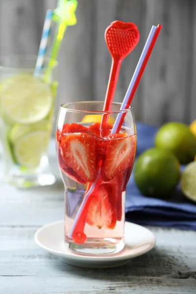 Cocktails with fresh strawberries and lemon lime on wooden background — Stock Photo, Image