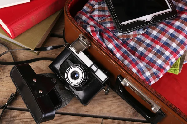 Packing suitcase for trip on wooden background — Stock Photo, Image