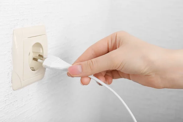 Mão colocando plug-in tomada de eletricidade de perto — Fotografia de Stock