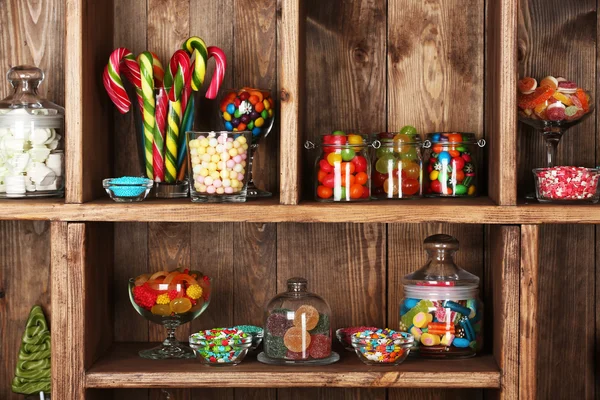 Dulces coloridos en frascos en estantes de madera de cerca —  Fotos de Stock