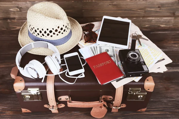 Packed suitcase of vacation items on wooden background — Stock Photo, Image