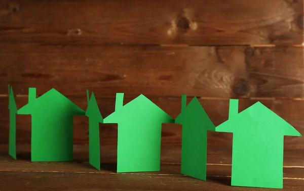Papíru domy na dřevěné pozadí — Stock fotografie
