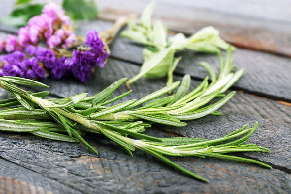 Green herbs and leaves on wooden  table, closeup — Stock Photo, Image