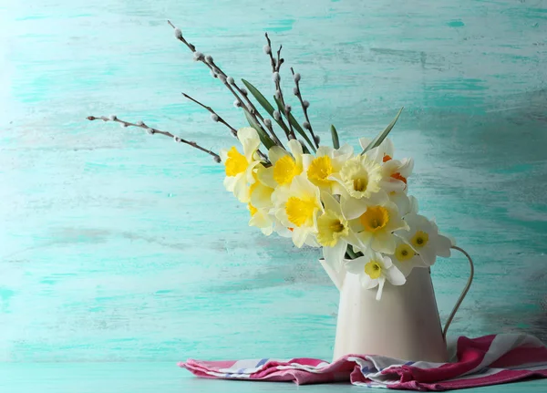 Flores narcisas frescas con ramitas de sauce sobre fondo de madera de color — Foto de Stock