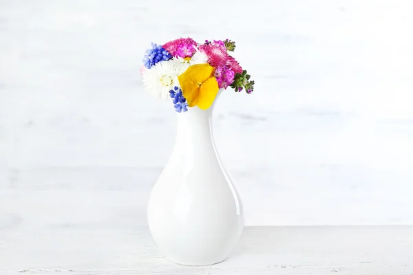 Fleurs printanières colorées sur fond blanc en bois — Photo