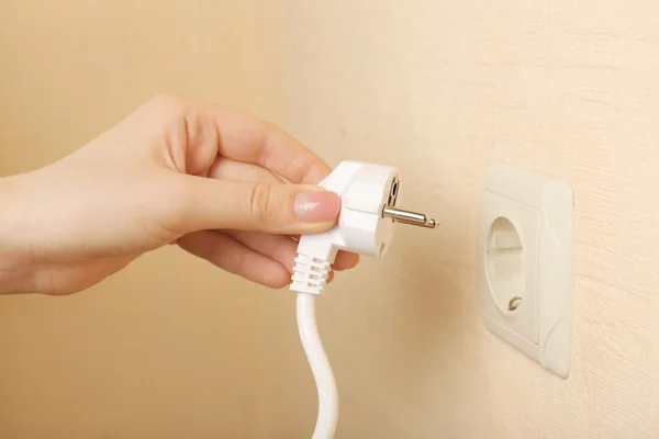 Hand putting plug in electricity socket close up Royalty Free Stock Photos