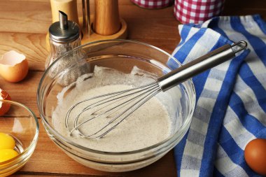 Hazırlık ahşap arka plan üzerinde cam kasede yumurta ile krem