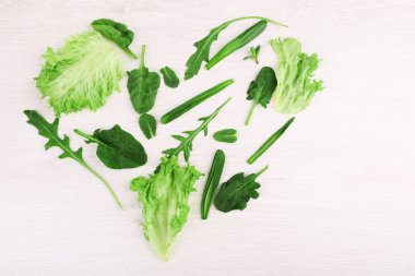 Yeşil yaprakları salata, ahşap masa üzerinde için kalbinde