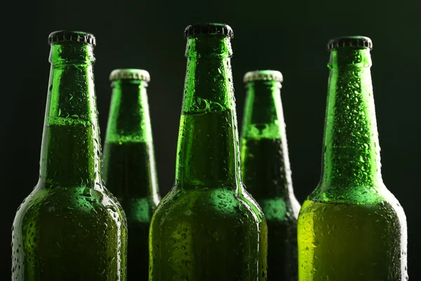 Szklane butelki piwa na ciemnym tle — Zdjęcie stockowe