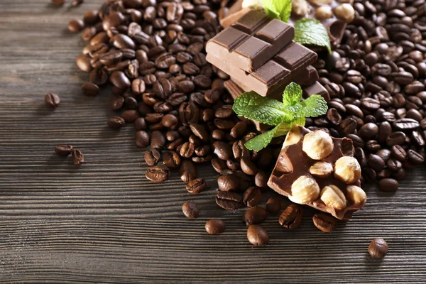 Chocolate with mint and coffee beans on wooden table, closeup — Stock Photo, Image