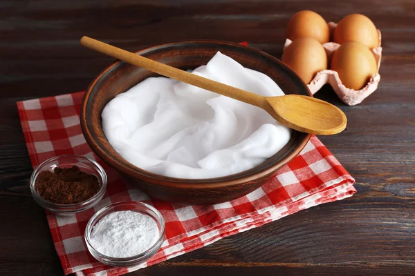Brancos de ovo chicoteado e outros ingredientes para creme na mesa de madeira, close-up — Fotografia de Stock