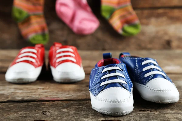 Zapatos coloridos para niños pequeños sobre fondo de madera — Foto de Stock