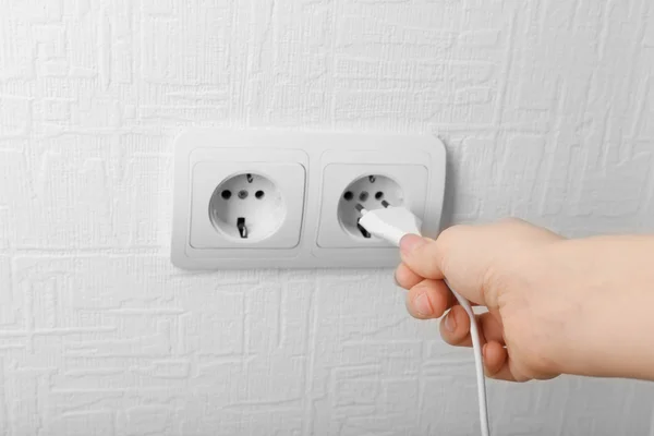 Mão colocando plug-in tomada de eletricidade de perto — Fotografia de Stock