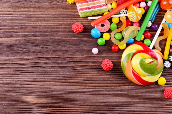 Colorful candies on wooden background — Stock Photo, Image