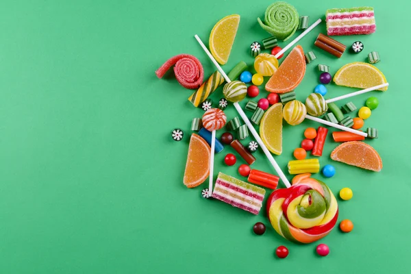 Красочные конфеты на зеленом фоне — стоковое фото