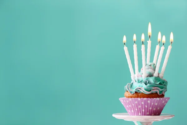 Delicious birthday cupcake on blue background — Stock Photo, Image