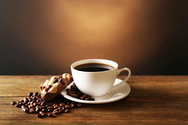 Kopje koffie met granen en chocolade op houten tafel op donkere achtergrond — Stockfoto