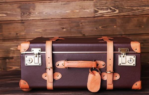 Suitcase on wooden background — Stock Photo, Image