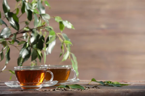 Šálky zeleného čaje na stole na dřevěné pozadí — Stock fotografie