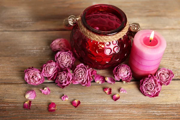 Spa ainda vida com vela e rosas secas no fundo de madeira — Fotografia de Stock