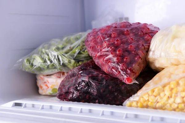 Buah beri beku dan sayuran dalam tas dalam freezer menutup — Stok Foto