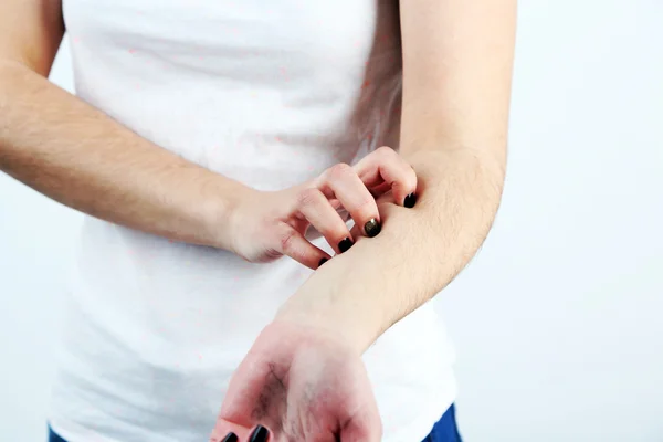 Woman has itch on gray background — Stock Photo, Image